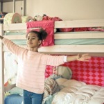 Little girl standing up with arms wide open
