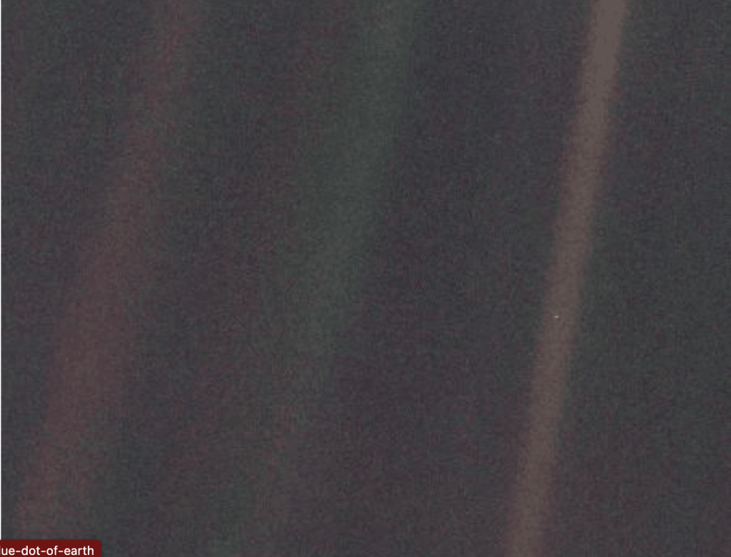 Earth visible as a tiny pale blue dot within a beam of light, taken by Voyager 1.
