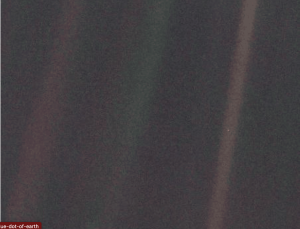 Earth visible as a tiny pale blue dot within a beam of light, taken by Voyager 1.